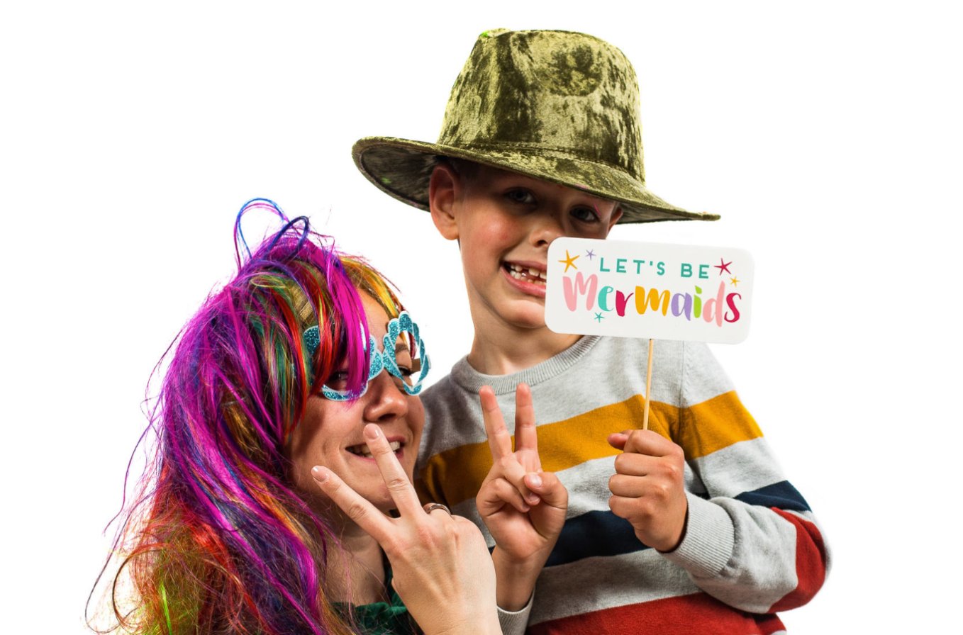 Moeder en zoon met hoed en bordje in de photobooth