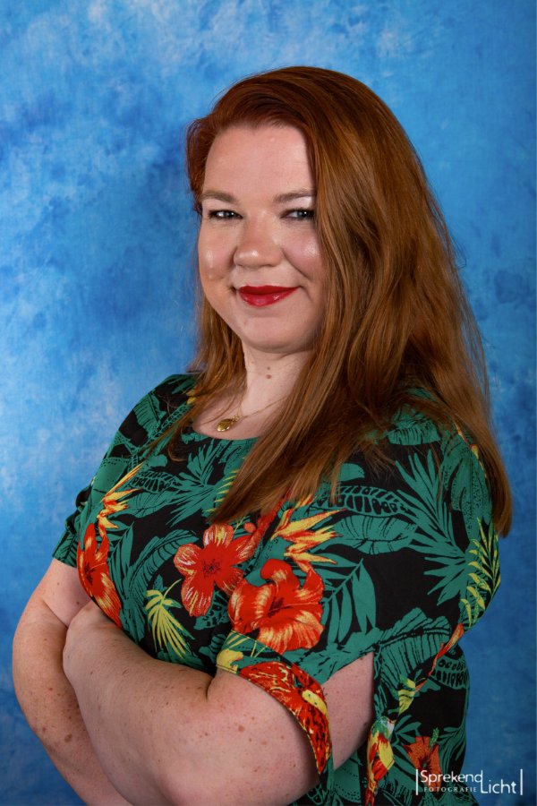 Portret van een vrouw met rood haar tegen een blauwe achtergrond