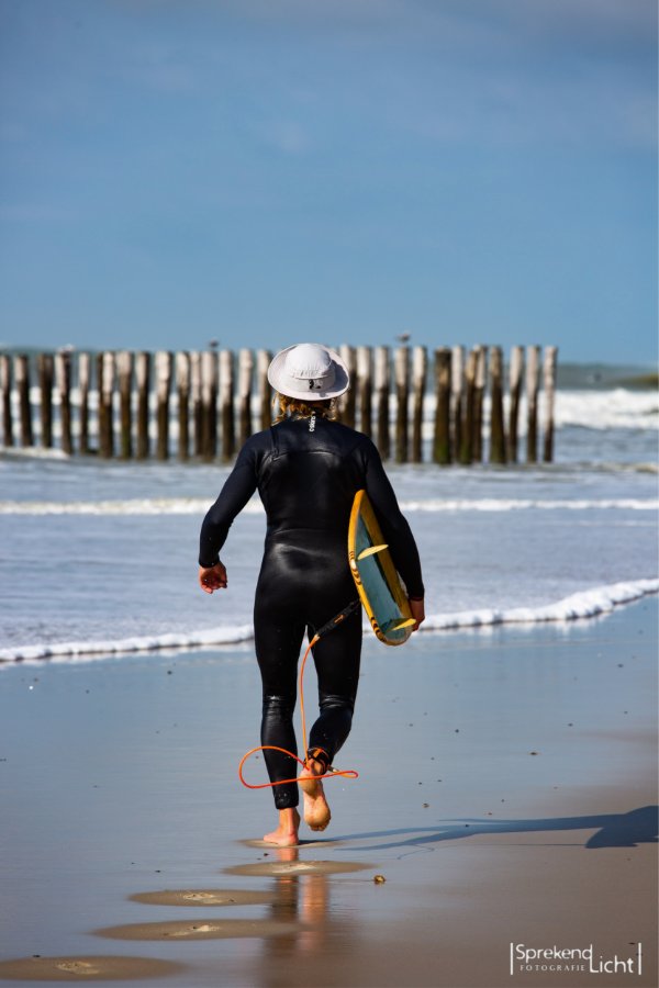 Surfer loopt met zijn board de zee in