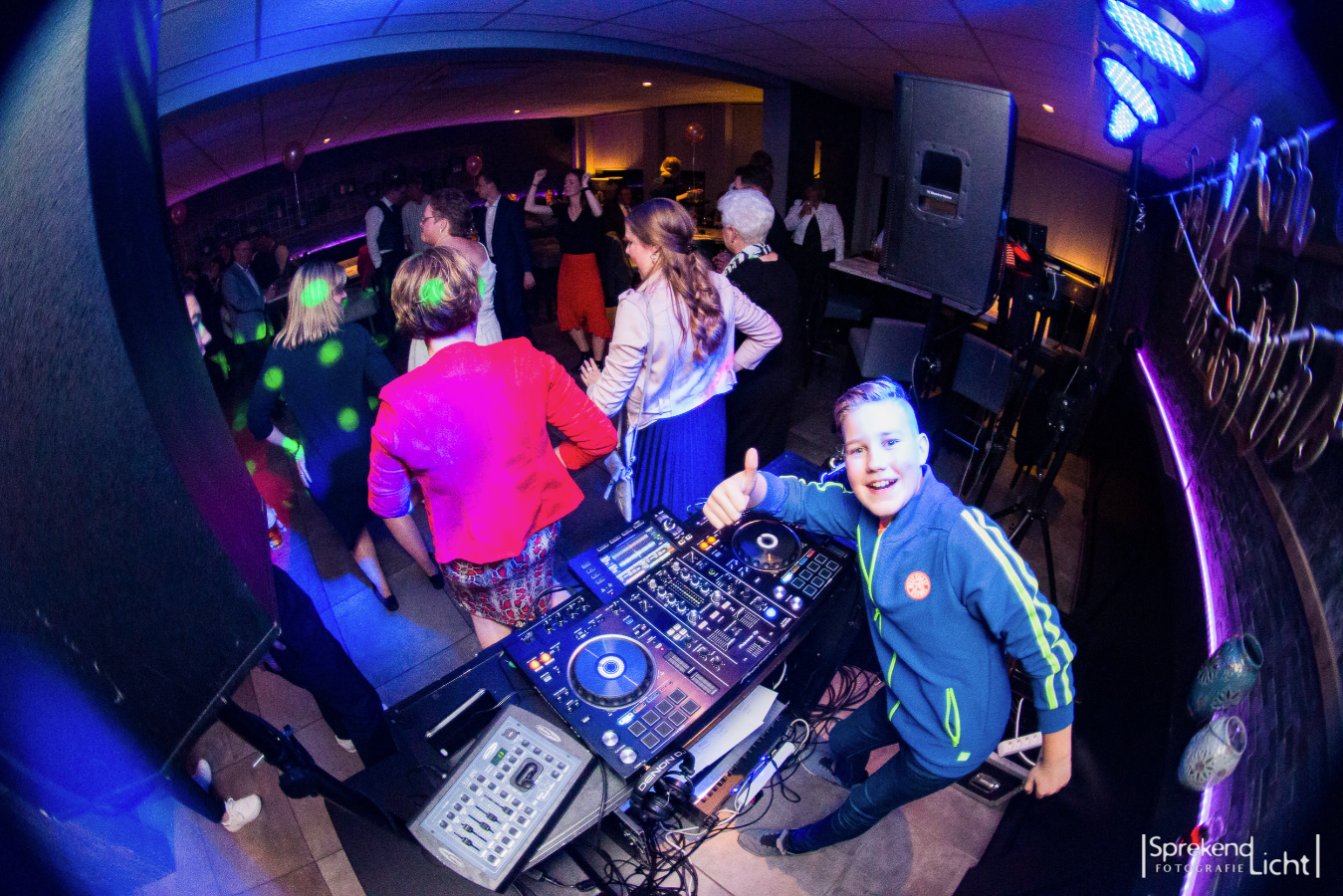Feestende gasten en een jonge dj