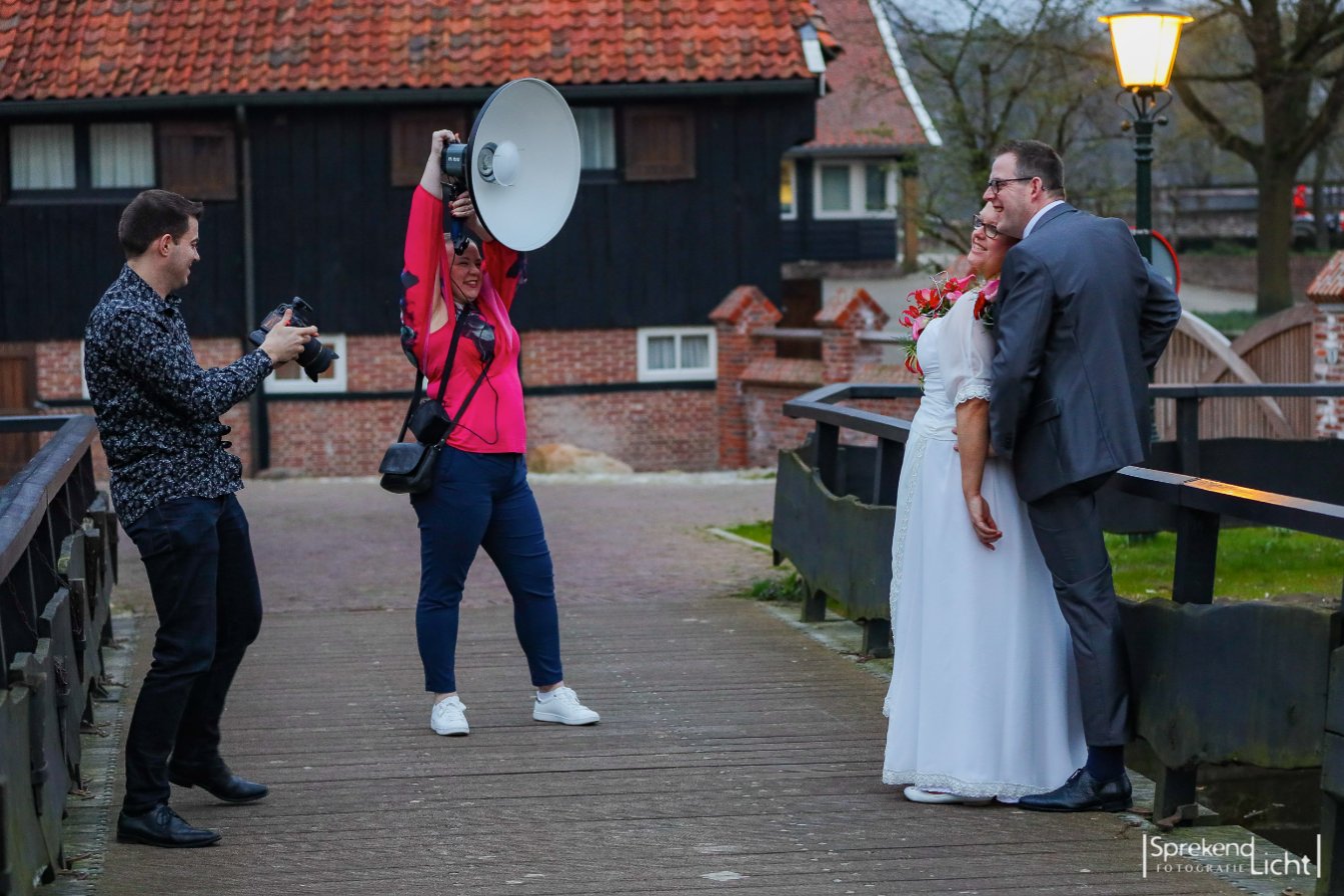 De fotografen aan het werk met een bruidspaar bij een molen